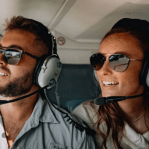 a man wearing sunglasses taking a selfie in a car